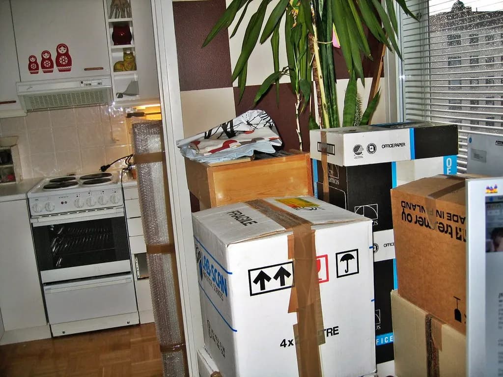 Cajas de mudanza embaladas y apiladas en la cocina de una vivienda