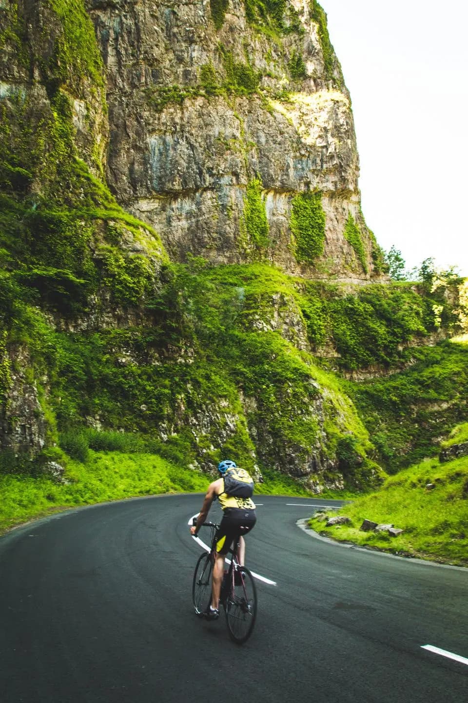 Ciclista subiendo una carretera de montaña, camino de su próxima ruta