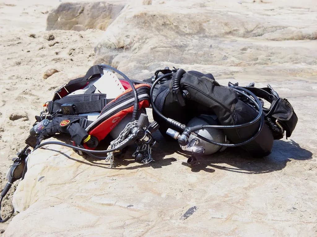 Equipo de buceo completo con regulador y chaleco preparado sobre las rocas